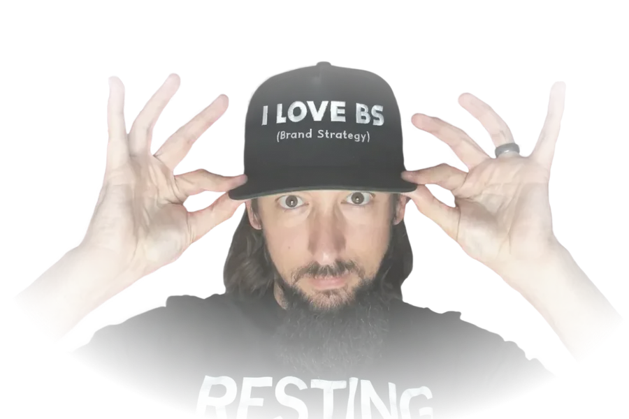 James Welbes holding a cap that reads 'I love BS - Brand Strategy'
