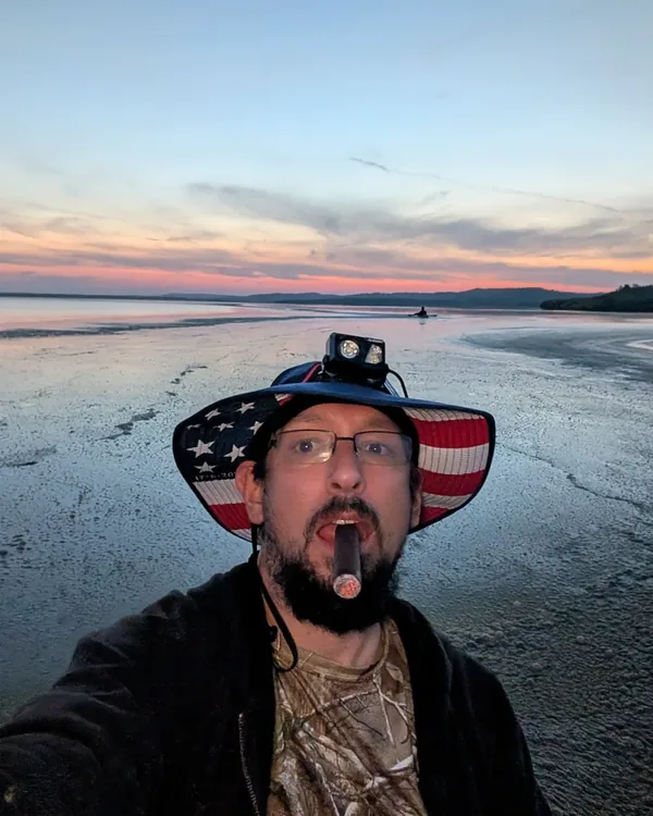 James Welbes at sunset over the water, cigar in hand